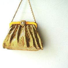 a gold purse hanging on a chain