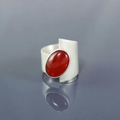 Modern Bypass Ring For Anniversary, Modern Red Cabochon Ring, Contemporary Gemstone Rings For Gifts, Contemporary Gemstone Rings For Gift, Modern Red Ruby Ring, Modern Polished Bypass Ring As Gift, Modern Bypass Ring With Polished Finish As Gift, Modern Round Ruby Ring, Modern Ruby Ring For Formal Occasions