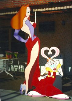 a woman in a red dress standing next to a cartoon character with a heart on it's chest