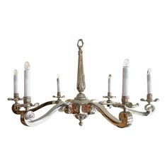 a chandelier with six lit candles hanging from it's sides and four on each side