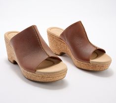 A leather upper and a cork-wrapped wedge make these gorgeous slides a must-have for fun in the summer sun. From Clarks Footwear. Brown Slides With Cork-bed Midsoles For Spring, Casual Cork Wedge Sandals For Vacation, Brown Cork Wedge Sandals For Summer, Leather Wedge Heel Slides For Beach, Summer Brown Cork Wedge Sandals, Casual Cork Slides For Summer, Brown Wedge Heel Mules With Cork-bed Midsoles, Leather Clogs With Wedge Heel For Vacation, Comfortable Cork Slides For Summer