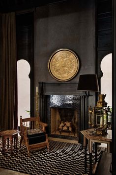 a living room filled with furniture and a fire place in front of a painting on the wall