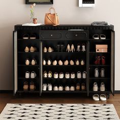 there is a black cabinet with many shoes on it and a rug in front of it