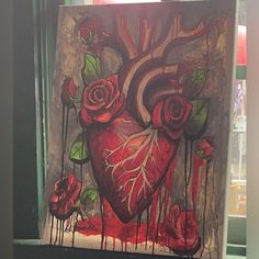 a painting of a heart with roses and blood dripping down the sides, on a window sill