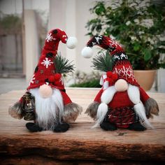 two gnomes sitting on top of a wooden table next to each other wearing red and white hats