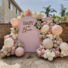 balloons and flowers decorate the entrance to a baby shower