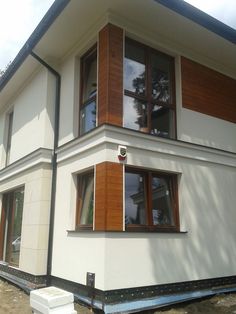 a large white house with wooden shutters and windows on the side of it's building