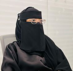 a person wearing a black outfit and glasses