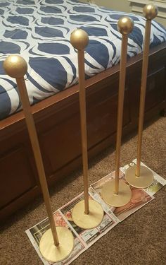 three brass candles are on the floor next to a bed