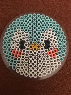 an odd looking object made out of plastic tubes on a brown carpeted floor with red and blue circles around it