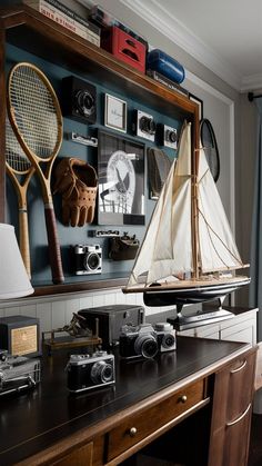 a wooden desk topped with a boat and two tennis rackets on top of it