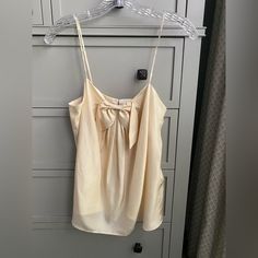 Pretty Silk Camisole, Fully Lined And Has Pretty Bow On Front And Covered Back Button Details. Chic Beige Tops With Tank Straps, Beige Camisole Tank Top For Daywear, Beige Tank Top For Daywear, Chic Beige Tank Top For Daywear, Chic Daywear Tank Camisole, Chic Sleeveless Camisole For Daywear, Chic Tank Top With Tank Straps For Daywear, Chic Tank Top For Daywear, Beige Camisole Top For Daywear