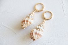 Natural sea shell hoop earrings in 18k gold plated.  Earrings hoop size: 12mm dia  Shell size: about 30mm Metal component: 18k gold plated brass base This listing is for a pair of earrings. ﹎﹎﹎﹎﹎﹎﹎﹎﹎﹎﹎﹎﹎﹎﹎﹎﹎﹎﹎﹎﹎﹎ ▲ Care instruction:  Please remove it before bathing or swimming.  Avoid your jewelry touching chemical such as hairsprays or perfumes.  Using soft cloth to clean your jewelry every time after wearing it, and store it in a dry and cool place. ▲ Gift packaging:  All products will be pack Handmade 14k Gold Filled Beach Earrings, Beachy Gold Dangle Earrings, Handmade 14k Gold-filled Earrings For Beach, Handmade 14k Gold Filled Earrings For Beach, Gold 14k Gold Filled Earrings For Beach, Gold Shell-shaped Hoop Earrings For Beach, Beachy Gold Shell Earrings, Gold Shell-shaped Hoop Earrings, Gold Shell-shaped Hoop Earrings For Pierced Ears