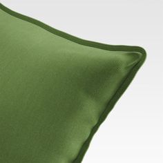 a green pillow on a white background with no image in the top right hand corner