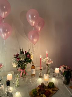 the table is set with candles, flowers and balloons