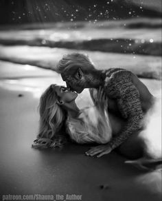 a man and woman kissing on the beach with stars in the sky behind them at night