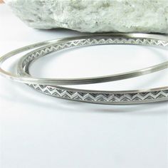 "Set of three sterling silver bangle bracelets perfect for everyday. These are very modern and sleek, the widest bangle is apx. 3mm wide and features a chevron or zig zag pattern, the other two measure apx. 1.5mm wide and are made from square sterling silver wire. The set measures about 1/4\" wide when worn together. Oxidized to highlight the zigzag pattern and add depth, polished to finish. You can never have too many bangle bracelets! Size 2 and 5/8\" - medium If you are not sure of your bangl Modern Stackable Sterling Silver Bangle Bracelet, Modern Sterling Silver Stackable Bangle, Zigzag Pattern, Sterling Silver Bangle Bracelets, Bangle Bracelet Set, Bracelets Set, Sterling Silver Bangle, Zig Zag Pattern, Silver Bangle Bracelets