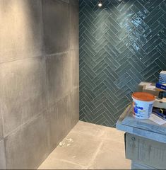 a bathroom with gray tile and blue walls in the shower area is being worked on