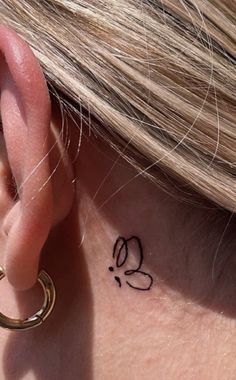 a close up of a person's ear with a tattoo on it