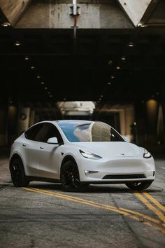 a white electric car parked in front of a building