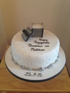 a white cake with pearls and a camera on top that says your first engagement and marriage