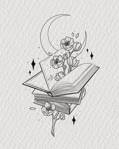 an open book sitting on top of a table next to a flower and moon tattoo