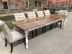 an old table and chairs are set up in front of a brick building with windows