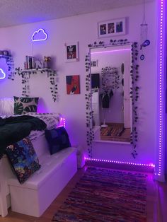 a bed room with a neatly made bed next to a mirror and lights on the wall