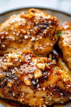 two pieces of chicken with sesame seeds on top