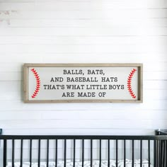 a baseball sign hanging on the wall above a crib in a room with white walls