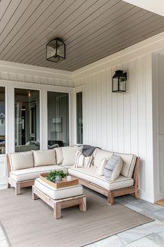 a white couch sitting on top of a wooden floor next to a table and chairs