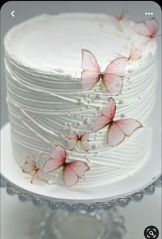 a white cake with pink butterflies on it