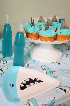 cute shark party plates to accent a party table Shark Birthday Cupcakes, Shark Fin Cupcakes, Pool Birthday, Beach Themed Party, Kids Party Food