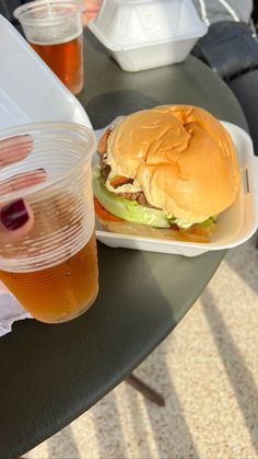 a hamburger and some drinks on a table