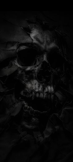 a black and white photo of a skull in the dark with its eyes closed,