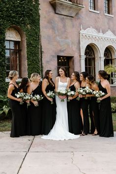 a group of women standing next to each other in front of a building