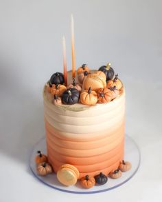 there is a cake decorated with pumpkins and candles