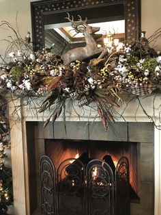 a fireplace decorated for christmas with pine cones, berries and deer head on it's mantle