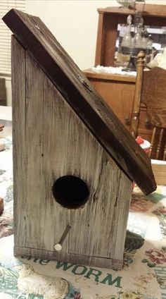 a wooden birdhouse sitting on top of a bed