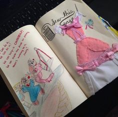 an open book with drawings on it and a drawing of a dress in the pages