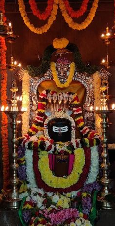 the idol is surrounded by flowers and candles