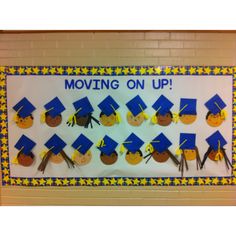 a bulletin board decorated with graduation caps and tassels for moving on up in the classroom