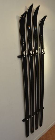 four skis are hanging on the wall next to each other