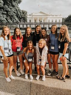 a group of young women standing next to each other in front of the white house