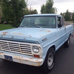 an old blue truck is parked on the street