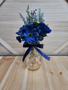 a vase filled with blue flowers on top of a wooden table