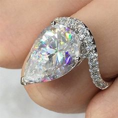 a woman's engagement ring with a pear shaped diamond