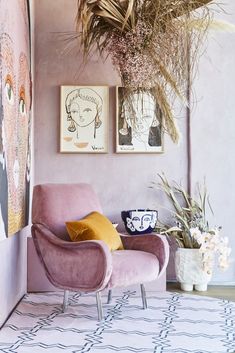 a pink chair sitting next to a potted plant on top of a white rug