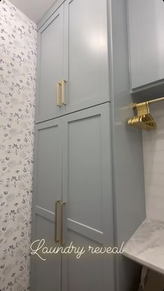 a bathroom with gray cabinets and gold handles