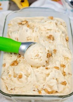 a scoop of ice cream in a glass dish with a green spatula on top